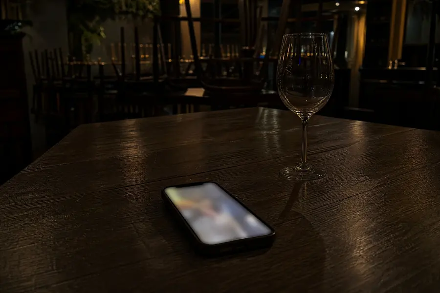 Móvil encendido sobre una mesa del restaurante vacío por la noche
